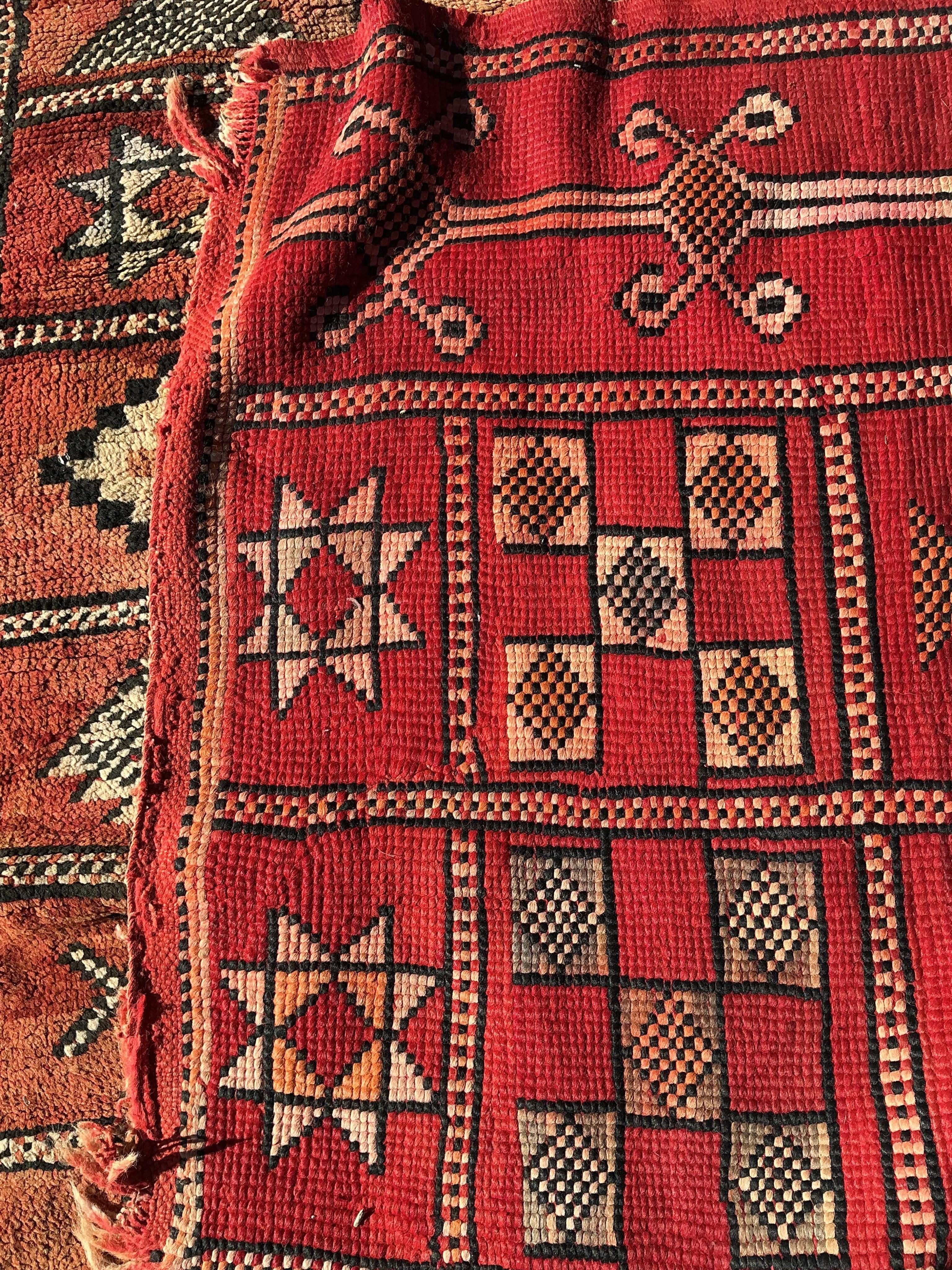 A Moroccan Berber pale red ground carpet, 300 x 190cm